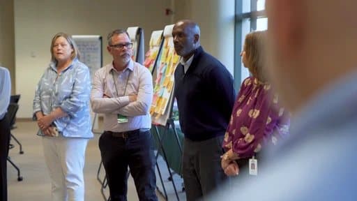 Leaders in conversation beside workshop boards