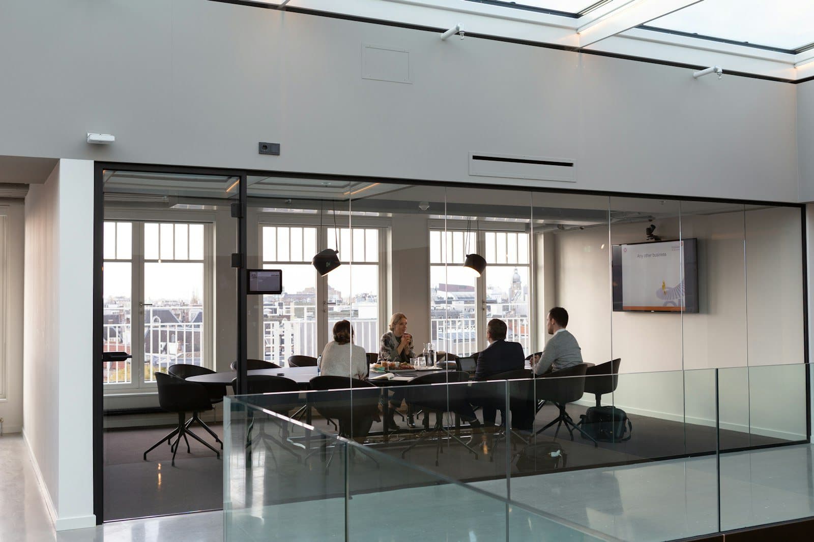 A leadership team meeting in a glass-walled boardroom