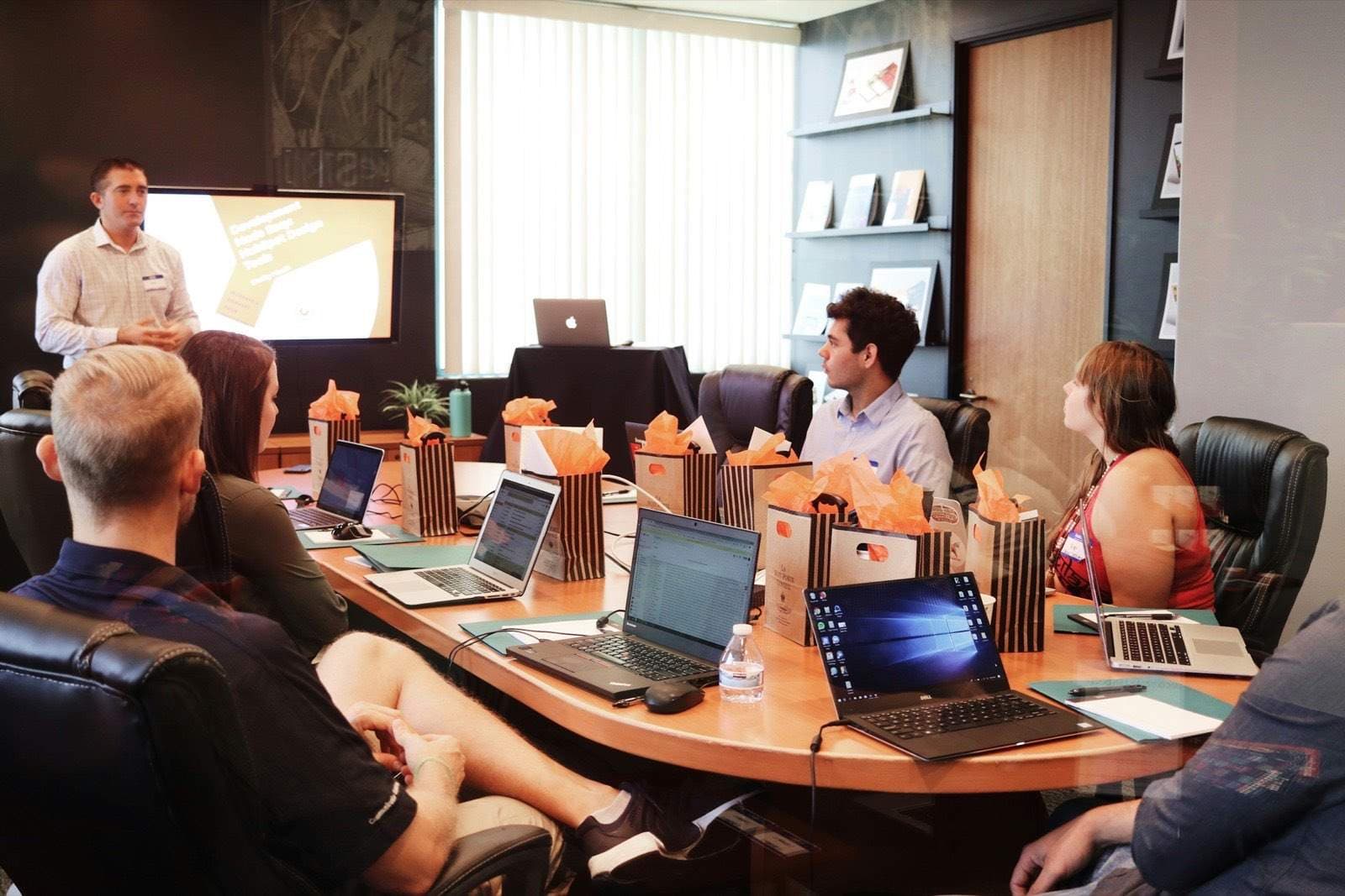 A man presenting to a team seated around a conference table
