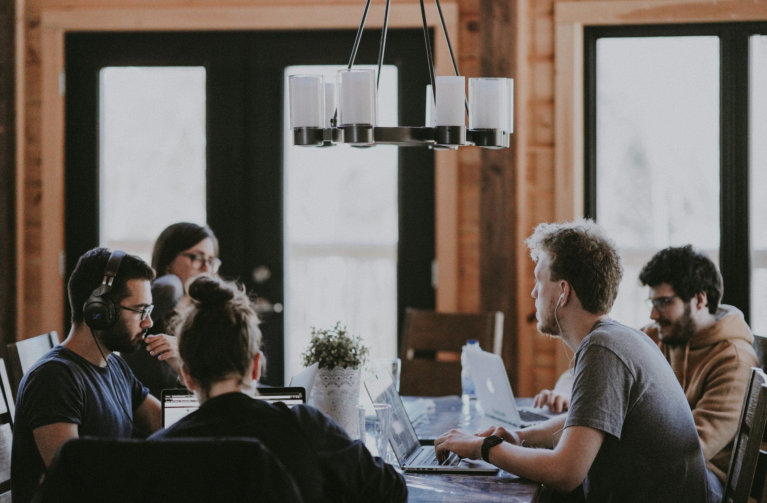 A small team working at laptops around a shared table