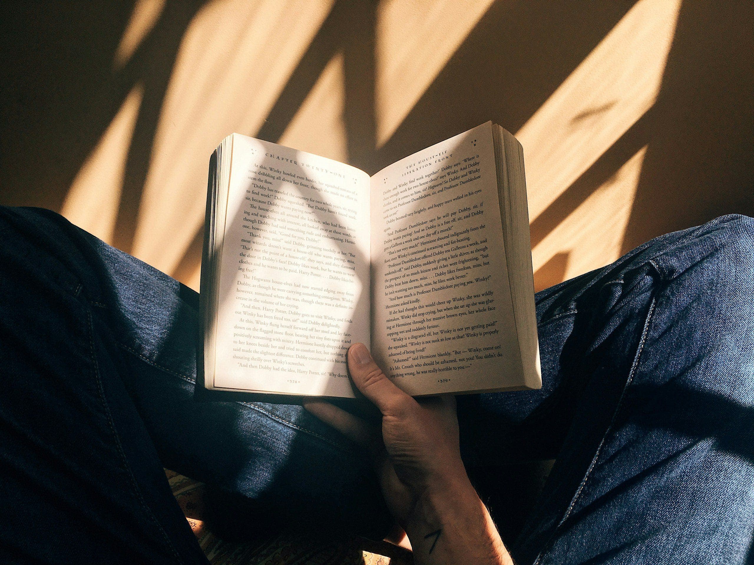 Hands holding an open book in warm afternoon light