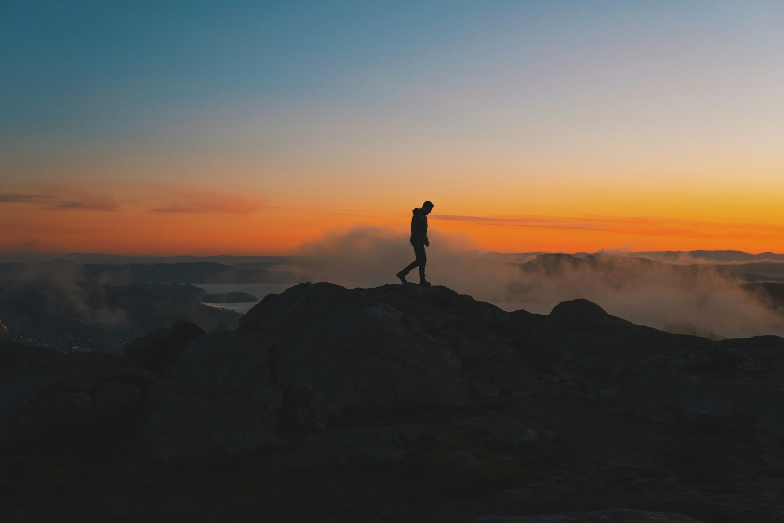 A lone walker on a mountain ridge at sunrise
