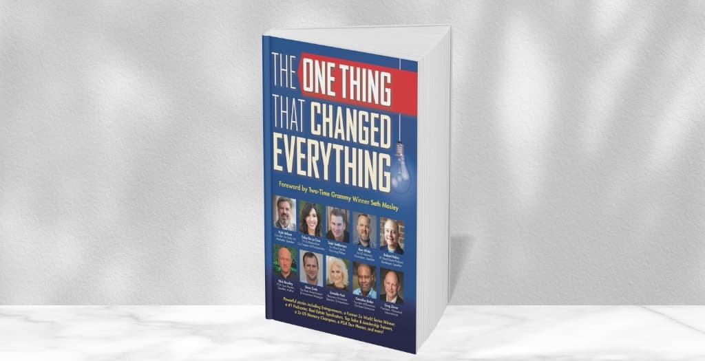 The printed book standing on a marble shelf, with its co-authors pictured on the cover