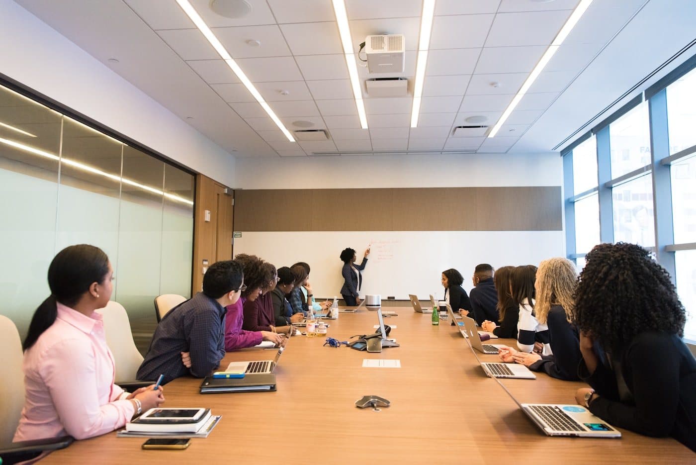 A cohort working around a long boardroom table