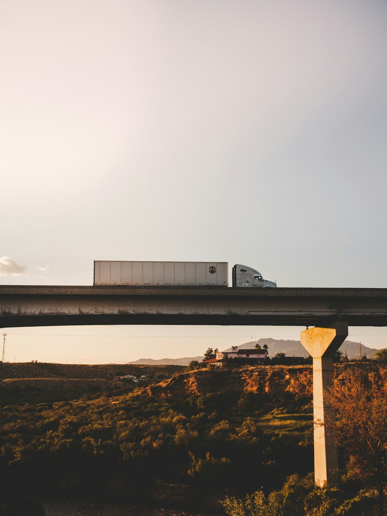 A haulage truck crossing a bridge at sunset